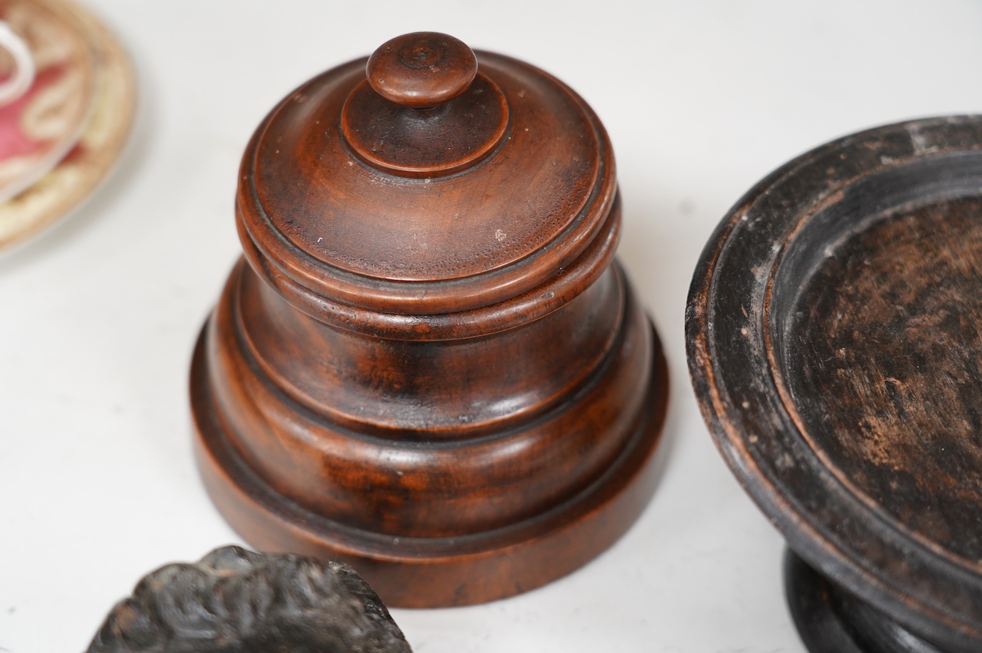 A 17th century carved oak mask corbel, another smaller, a small tazza and a carved wood pot and cover, tallest 19.5cm. Condition - fair to good